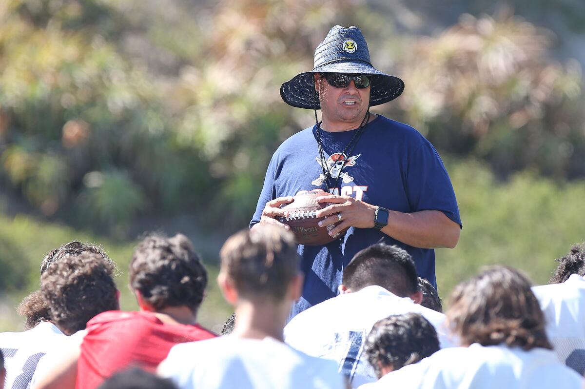 Coach Joel “Bubba” Gonzalez addresses the team after practice at Orange Coast College on Friday.