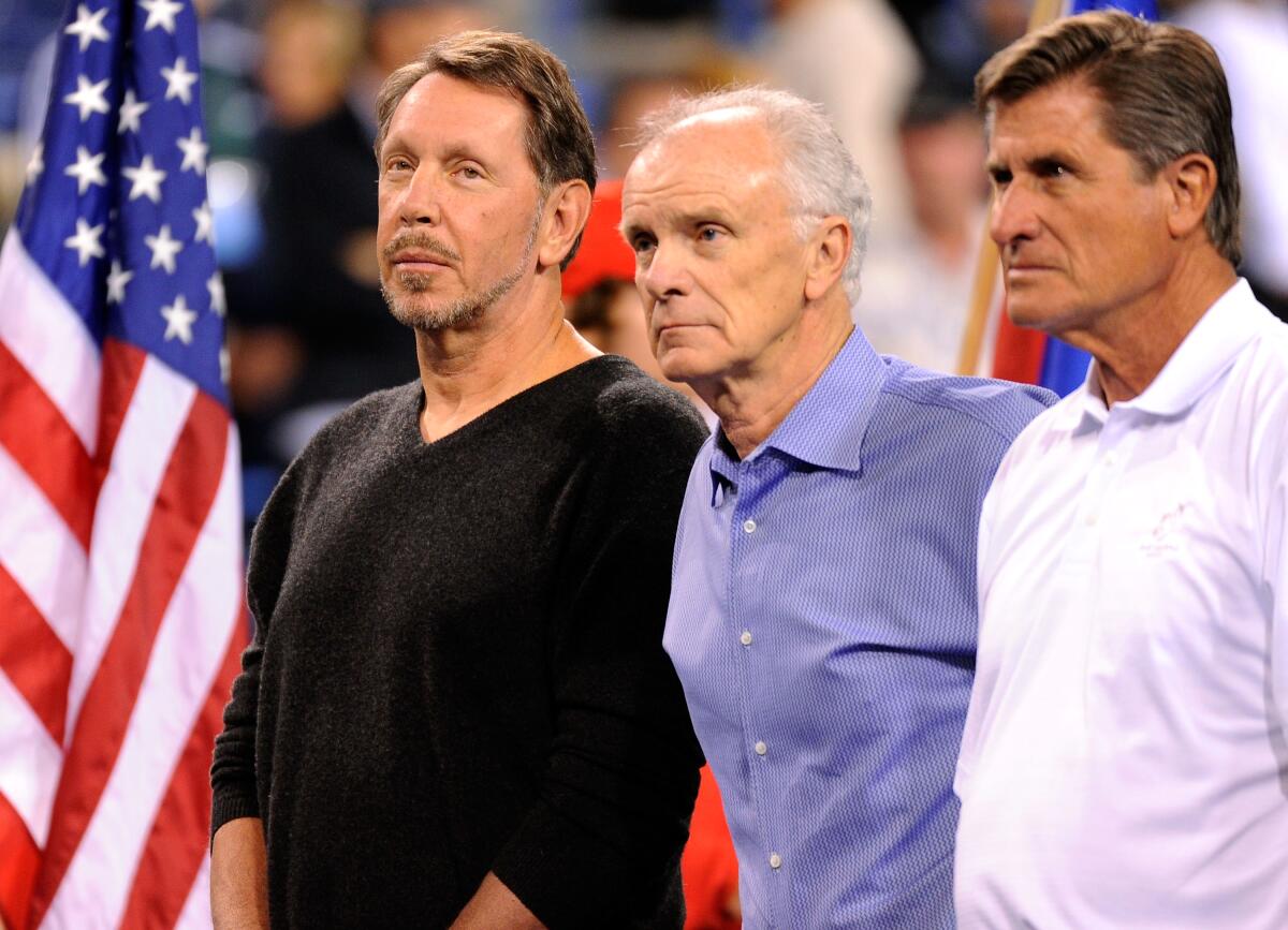 Larry Ellison, left, stands next to Raymond Moore, center, and Charlie Pasarell before a match at the BNP Paribas Open.