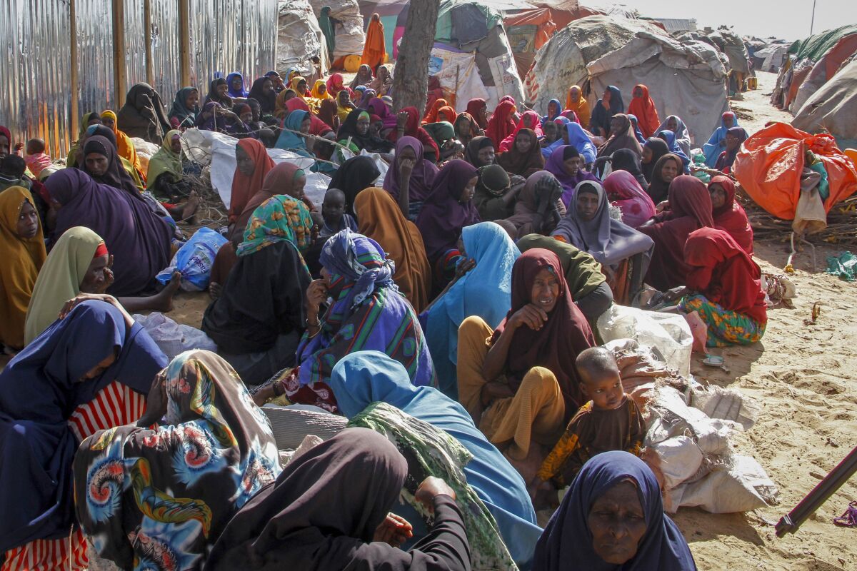 FILE - Somalis who fled drought-stricken areas sit at a makeshift camp on the outskirts of the capital Mogadishu, Somalia on Feb. 4, 2022. Two U.N. food agencies issued stark warnings on Monday, June 6, 2022 about multiple, looming food crises on the planet, driven by climate “shocks” like drought and worsened by the repercussions of the COVID-19 pandemic and the war in Ukraine that have sent fuel and food prices soaring. (AP Photo/Farah Abdi Warsameh, File)