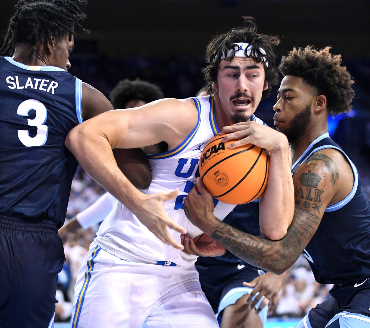 UCLA's Jaime Jaquez Jr. grabs a rebound between Villanova's Brandon Slater and Justin Moore.