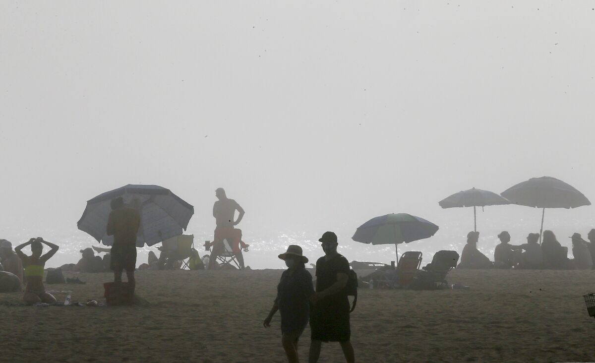 Afternoon fog and cool temperatures limited the number of visitors to Huntington Beach on April 25, 2020. Beaches in neighboring Los Angeles County remain closed because of the coronavirus outbreak.