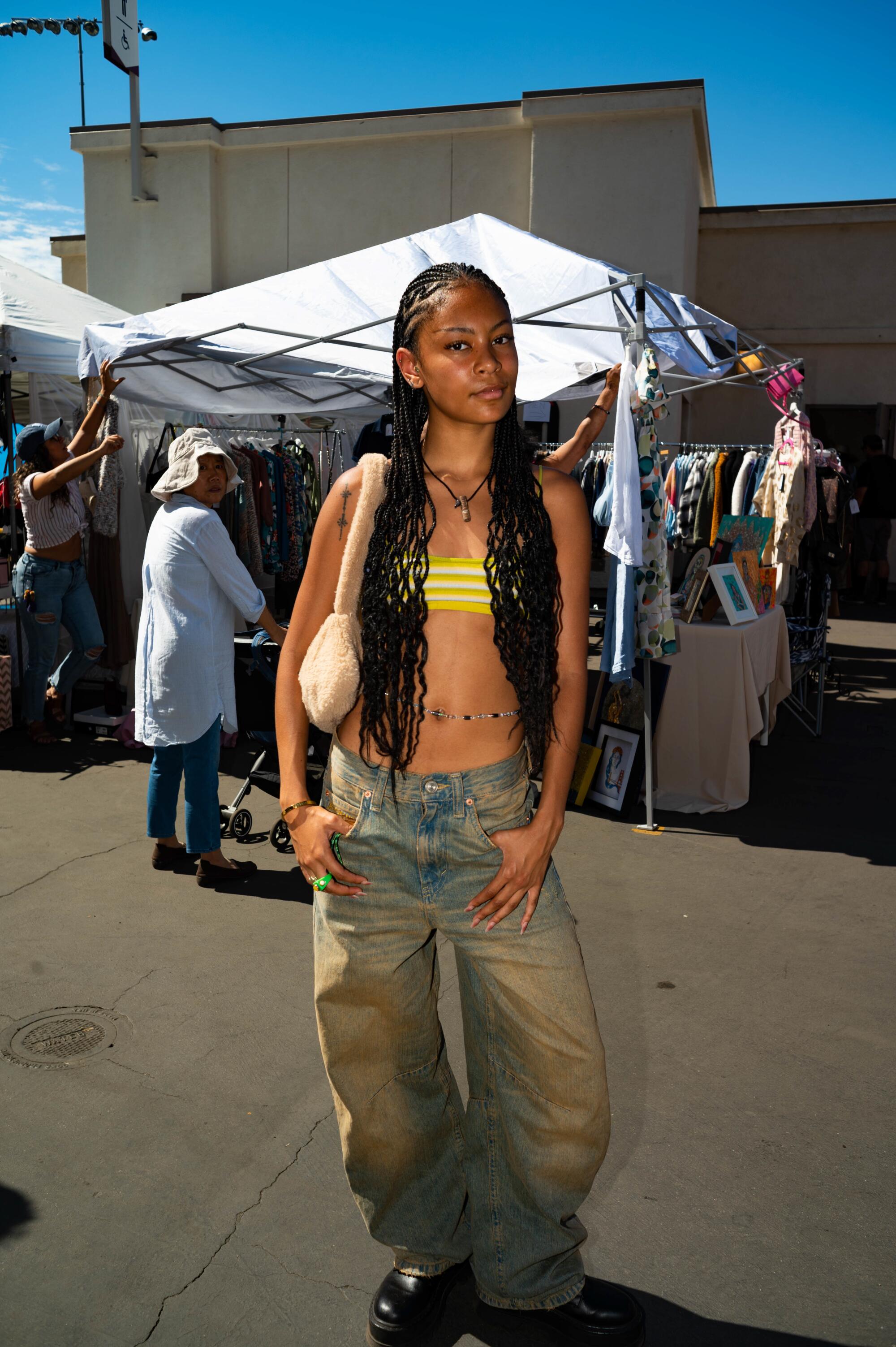 Naisha Dos Santos wearing thrifted boots and bag, Urban Outfitters jeans and top, Brazilian waist beads