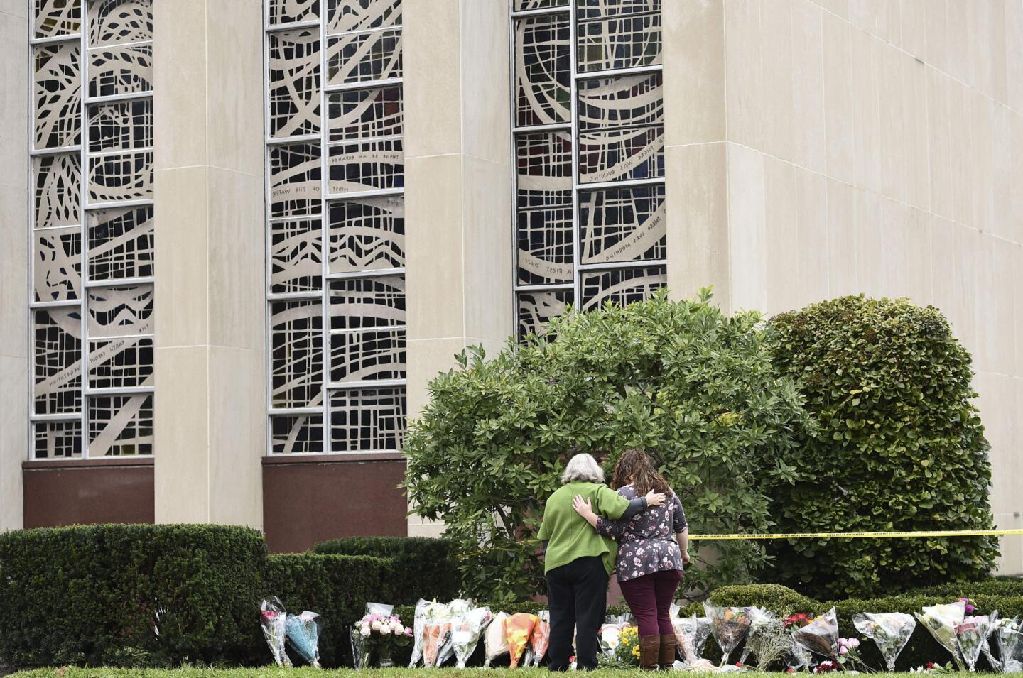 Women embrace in front of memorial outside the Tree of Life synagogue in Pittsburgh on Oct. 28, 2018, after a shooting there the previous day left 11 people dead.