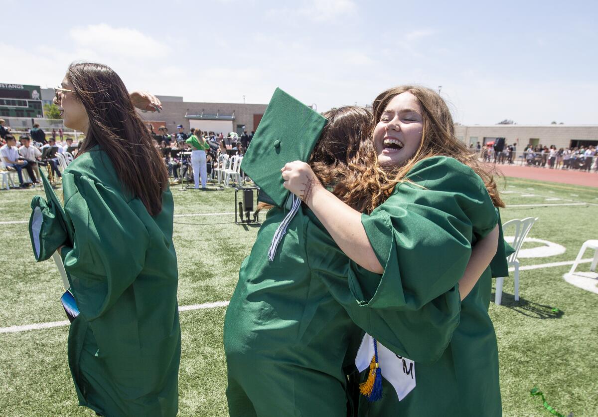 Jenna Paxson gets a hug from Caitlyn Roum Thursday following Costa Mesa High School's 60th graduation ceremony.
