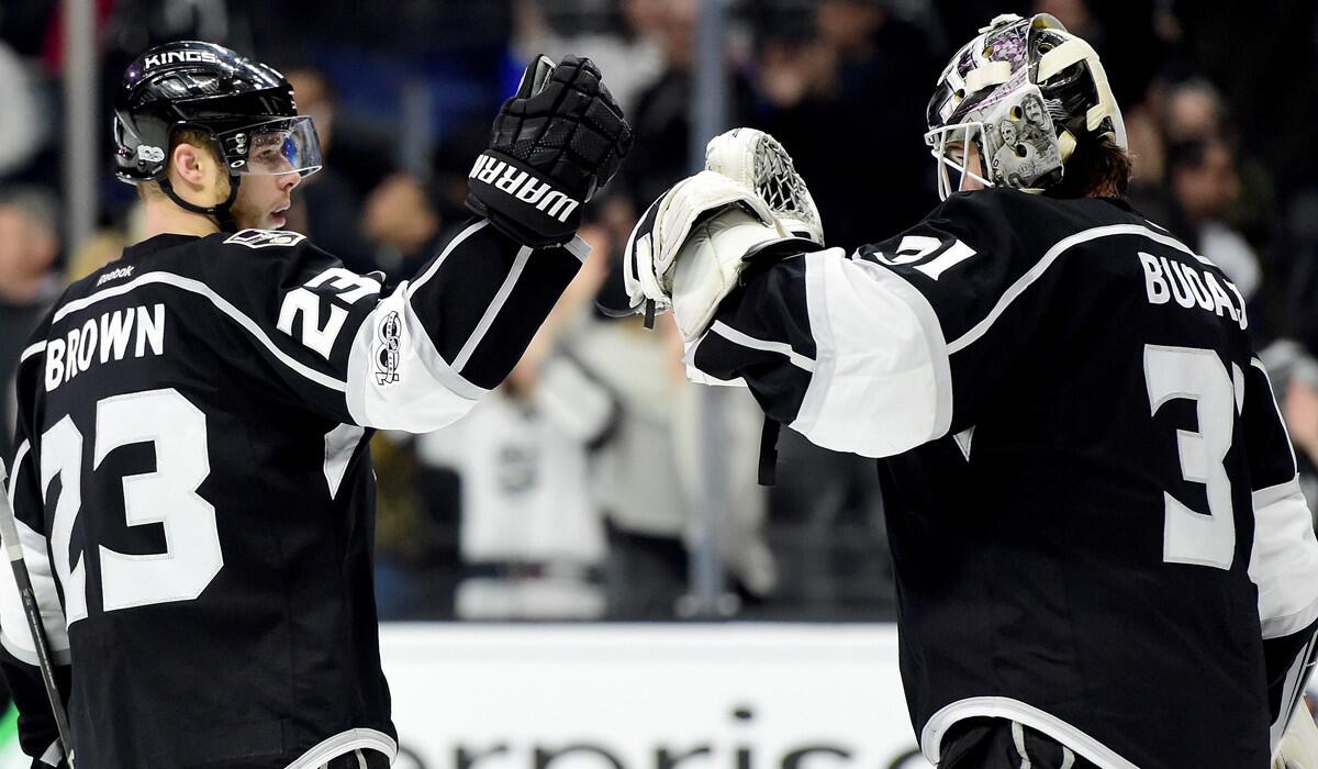 Kings goalie Peter Budaj (31) celebrates the Kings' 5-0 shutout win over the Colorado Avalanche with teammate Dustin Brown (23) on Wednesday.