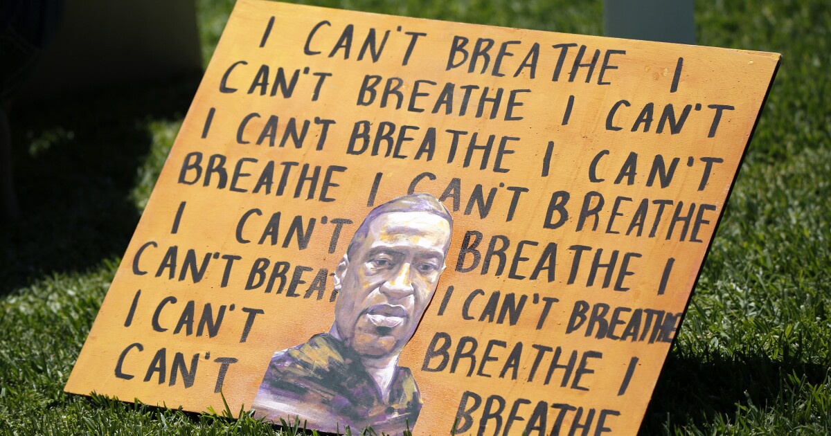 A sign at an Irvine protest showing the words 'I can't breath' and a portrait of George Floyd.