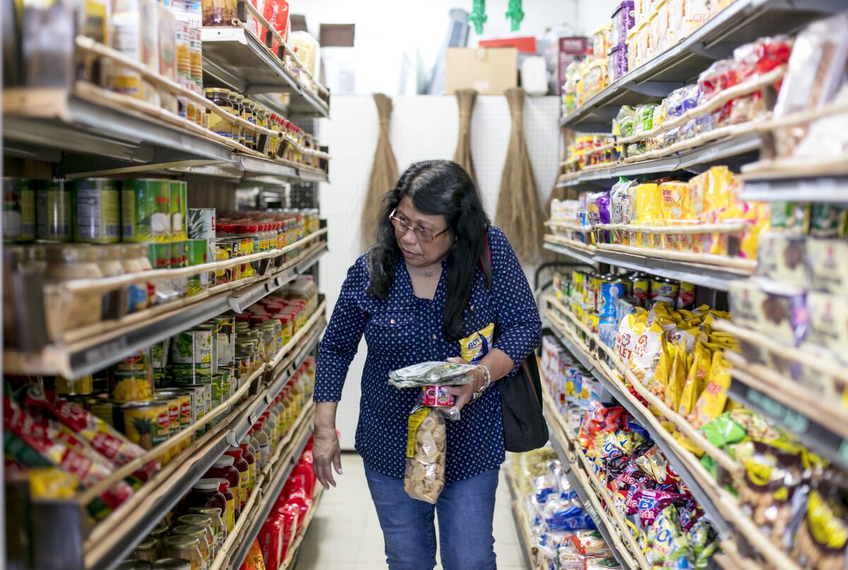 una mujer compra comida en el mercado Chaaste Family Market en Pasadena