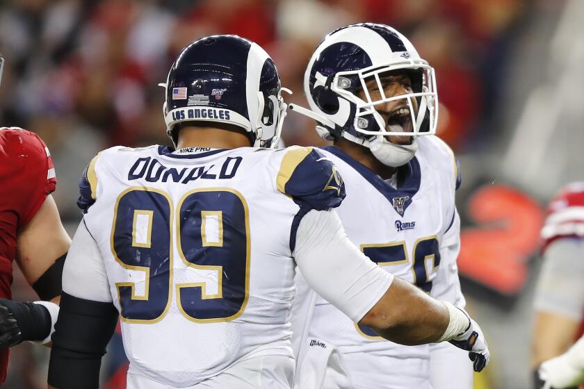 Rams linebacker Dante Fowler Jr. celebrates with teammate Aaron Donald after recording one of six second-half sacks of 49ers quarterback Jimmy Garoppolo on Dec. 21, 2019.