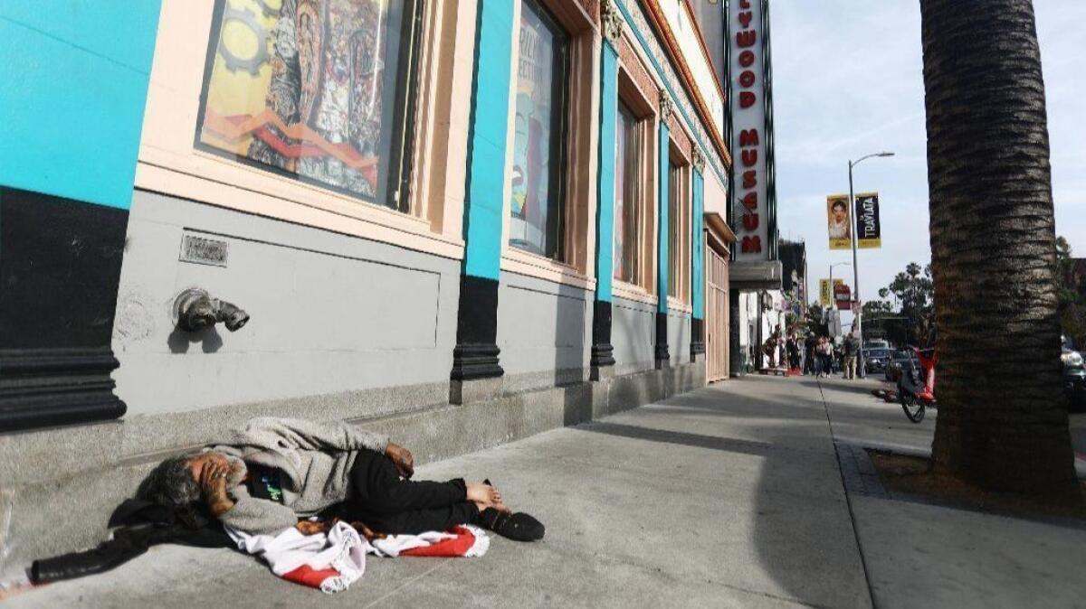 A man sleeps on the sidewalk on Highland Avenue near Hollywood Boulevard on June 6.