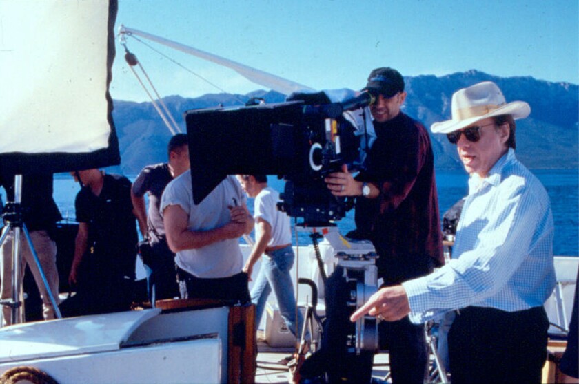 A man in a cowboy hat directs a movie crew