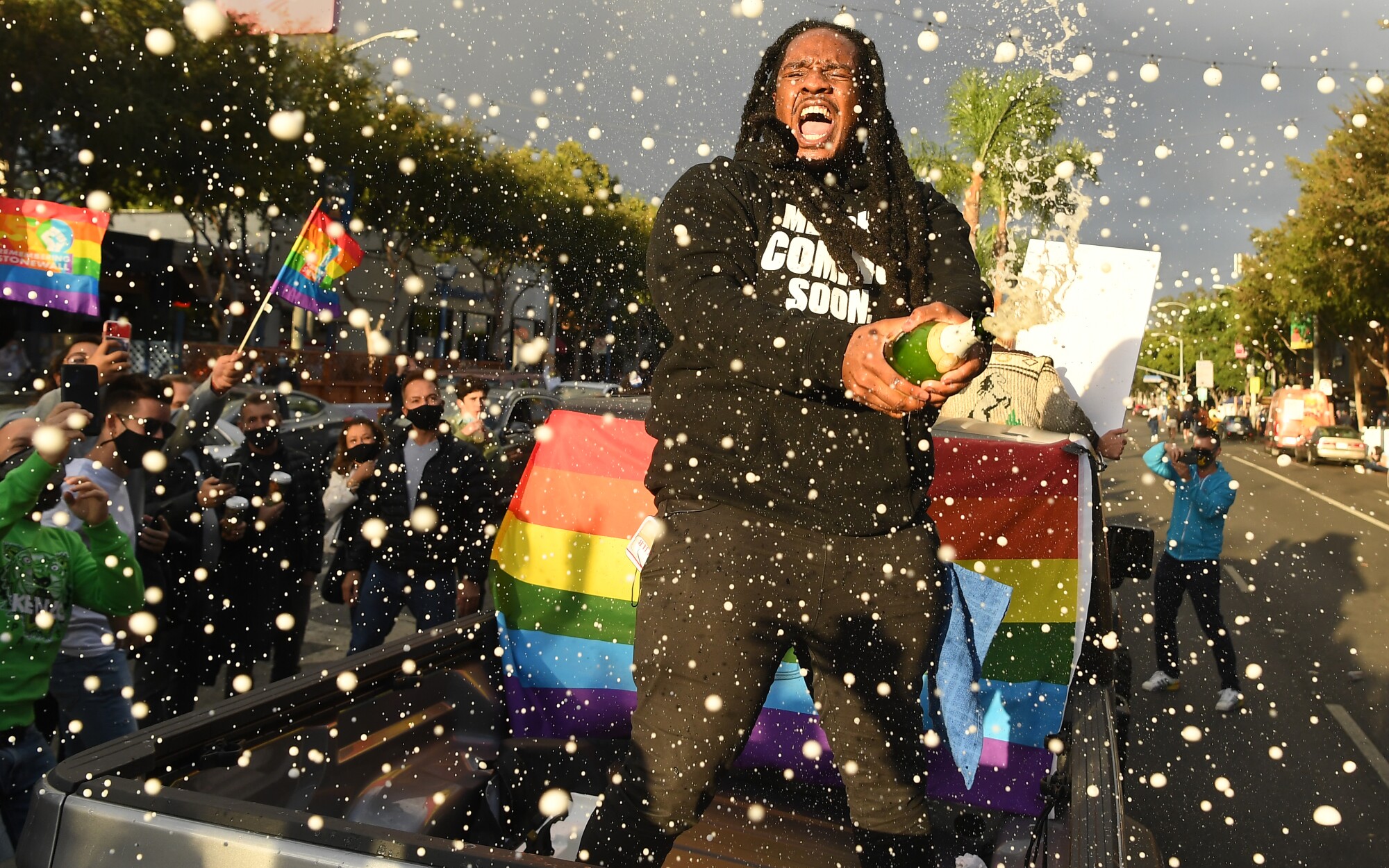 A reveler celebrates Joe Biden's victory with a bottle of Champagne.