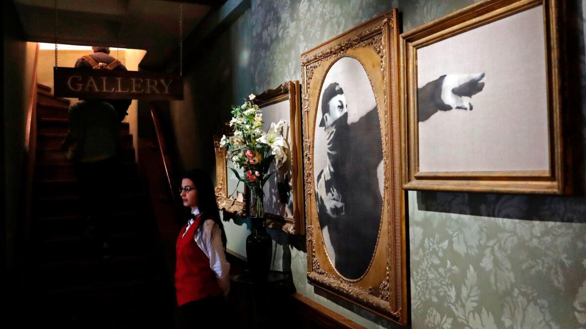 A Palestinian waitress stands inside the lobby at street artist Banksy's newly opened Walled Off hotel in the Israeli occupied West Bank town of Bethlehem, on March 3, 2017.