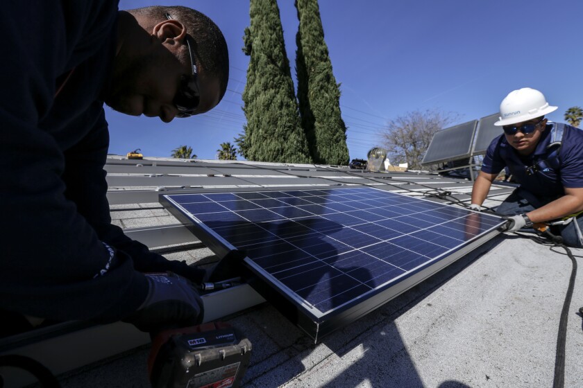 California added more than 20,000 new solar jobs in 2015, more than half of the nation's total. Above, Elgin Clark, left, and Edgar Palma of Sunrun home solar company install a solar panel on a home in Van Nuys.