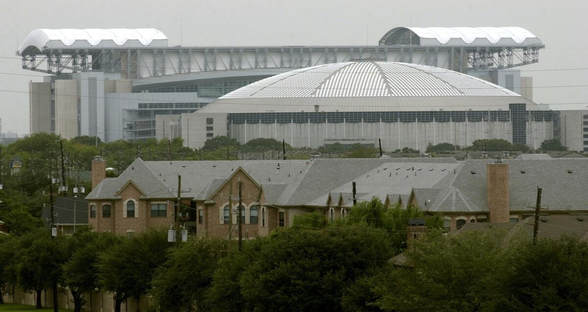The Houston Astrodome is dwarfed by its replacement, Reliant Stadium, in 2003.