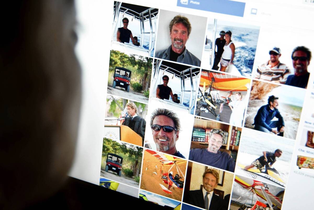 Belize police have urged John McAfee to come forward, saying he is only a person of interest, rather than a murder suspect. McAfee reportedly fears he'll be killed if police find him. Above, a woman views a Facebook page belonging to McAfee.