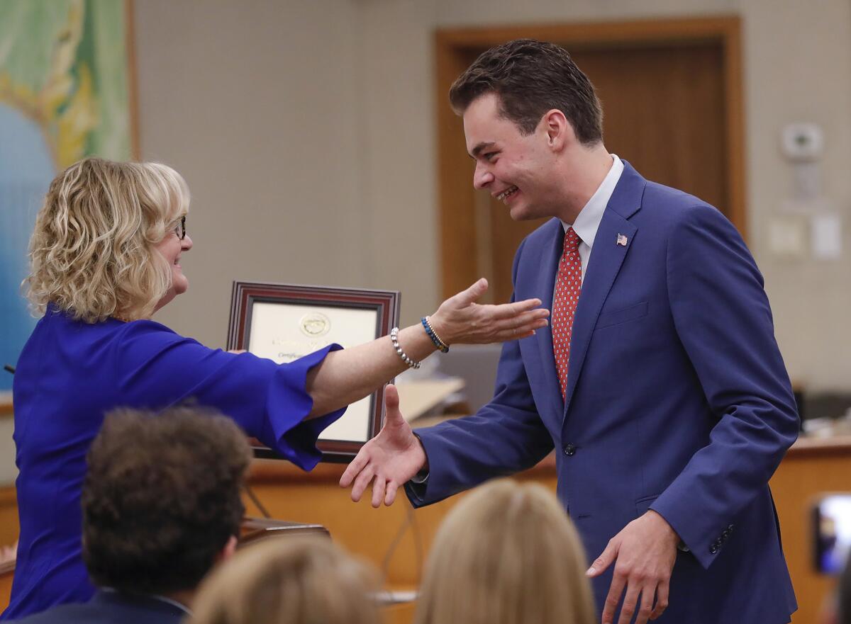 Newly sworn-in councilman Alex Rounaghi, right, is congratulated by Orange County Supervisor Katrina Foley on Tuesday.