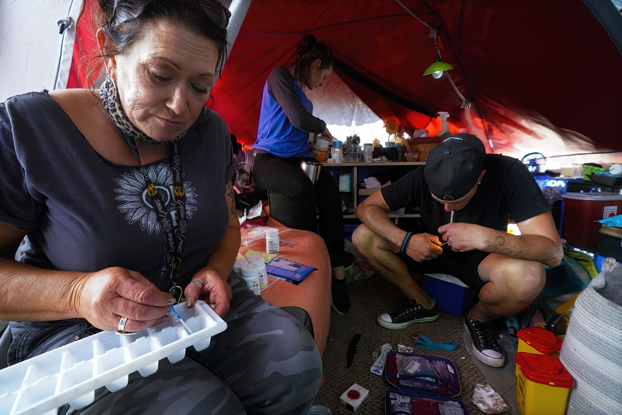 A man smokes fentanyl inside his tent at a homeless encampment in San Diego