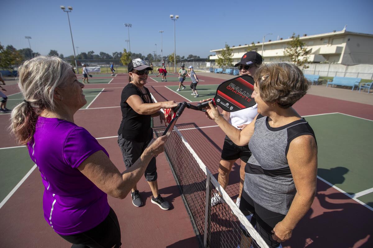 Savannah Bonifay, right, joins pickleball players at the Worthy Park courts in Huntington Beach.
(Allen J. Schaben / Los Angeles Times)
