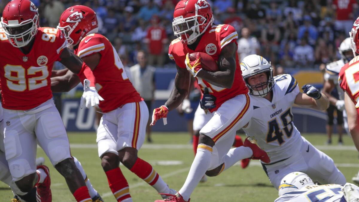 Kansas City Chiefs receiver Tyreek Hill leaps over defenders on his way to a 91-yard punt return for a touchdown in the first quarter at StubHub Center on Sunday.