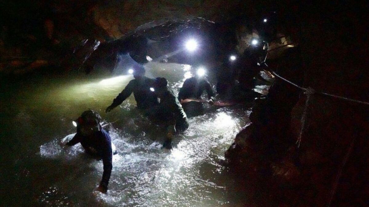 This photo released by the Royal Thai Navy shows Thai Navy Seals navigating a flooded section of the Tham Luang Nang Non cave to search for 12 boys and their soccer coach.