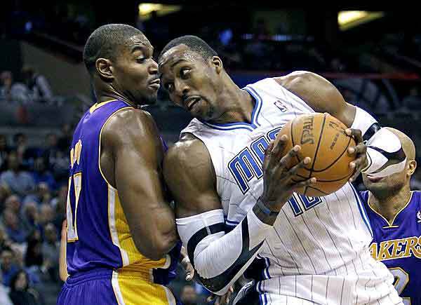 Lakers center Andrew Bynum takes it on the nose as Magic center Dwight Howard spins toward the basket in the second half Friday night in Orlando. Howard would lead the Magic to a 92-80 victory with 21 points and 23 rebounds.