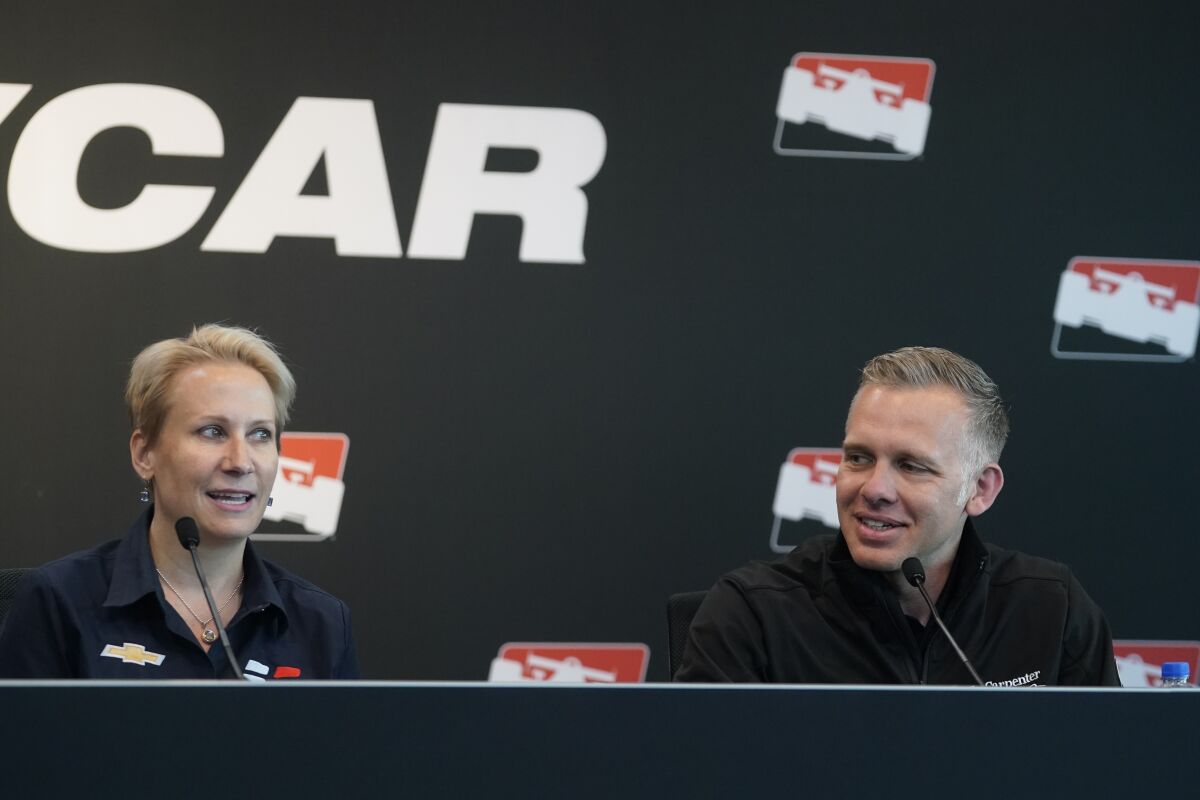 Beth Paretta, left, Team Principal, Paretta Autosport, speaks during a news conference at the Indianapolis Motor Speedway as Ed Carpenter listens, Tuesday, April 19, 2022, in Indianapolis. Paretta, announced today at the Indianapolis Motor Speedway that Paretta Autosport will return to the NTT INDYCAR Series to campaign in multiple races in 2022. (AP Photo/Darron Cummings)