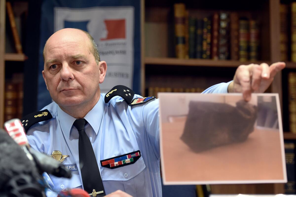 During an April 2 news conference, French Gendarmerie Gen. David Galtier holds up a picture of the flight data recorder that was recovered from the wreckage of the Germanwings plane that crashed in the French Alps.