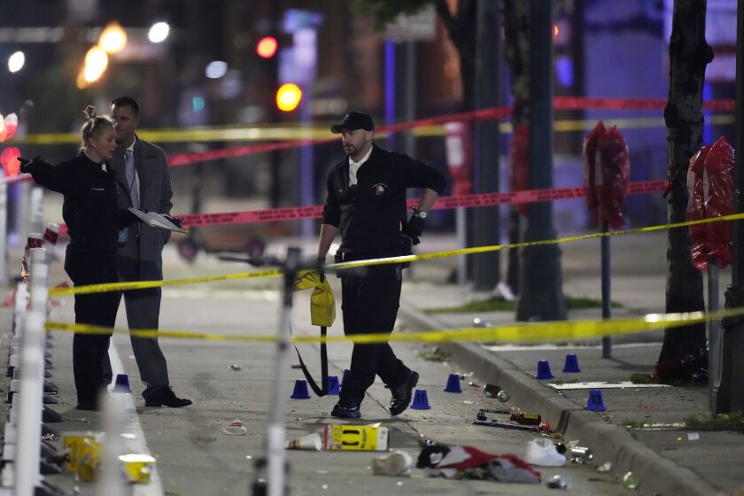 Denver Police Department investigators work the scene of a mass shooting along Market Street between 20th and 21st avenues during a celebration after the Denver Nuggets won the team's first NBA Championship early Tuesday, June 13, 2023, in Denver. (AP Photo/David Zalubowski)