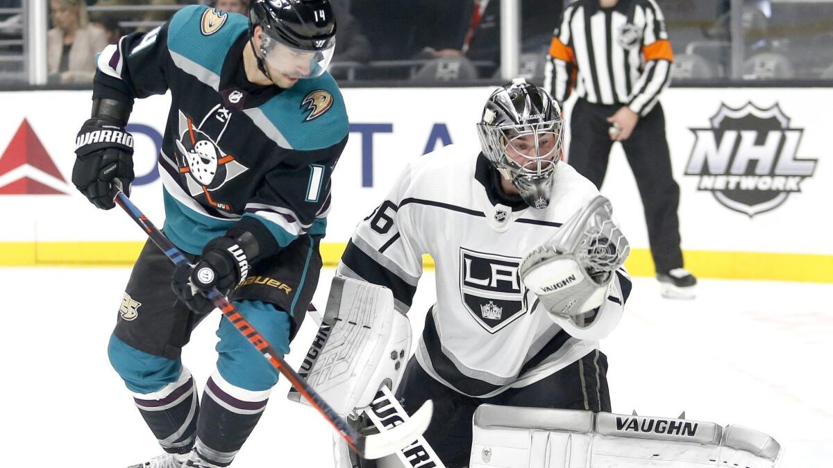 Kings goalie Jack Campbell (36) makes a save next to Ducks forward Adam Henrique (14) during the first period on Monday.