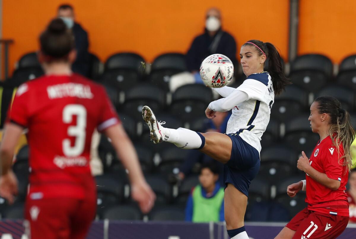 Tottenham Hotspur's Alex Morgan, center, vies for the ball with Reading's Natasha Harding