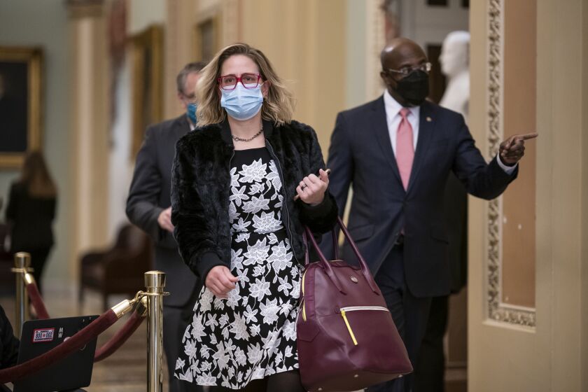 FILE - In this Feb. 9, 2021, file photo Sen. Kyrsten Sinema, D-Ariz., and Sen. Raphael Warnock, D-Ga., right, arrive as the second impeachment trial of former President Donald Trump starts in the Senate, at the Capitol in Washington. (AP Photo/J. Scott Applewhite, File)