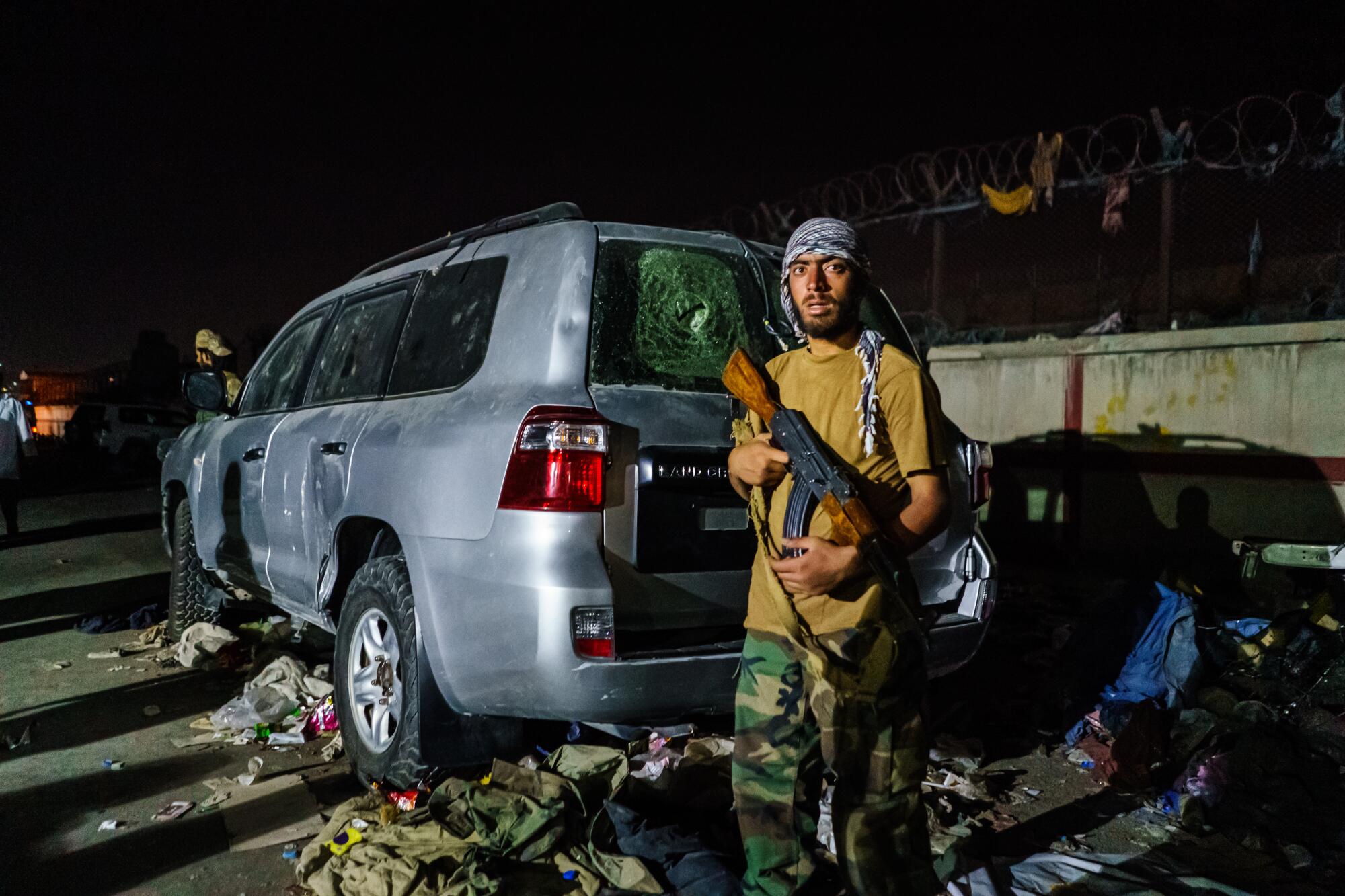 A Taliban fighter guards a checkpoint outside the airport in Kabul on Thursday night.