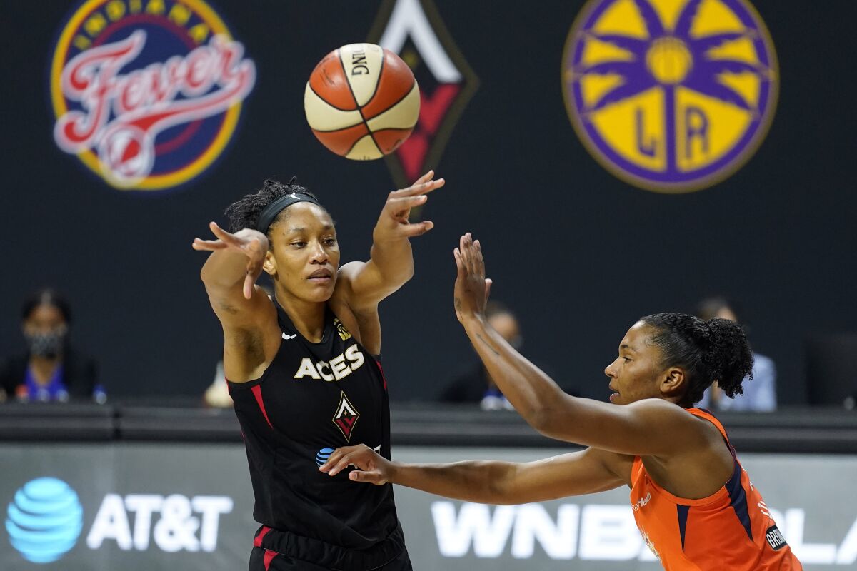 Las Vegas Aces center A'ja Wilson passes the ball in front of Connecticut Sun forward Alyssa Thomas.