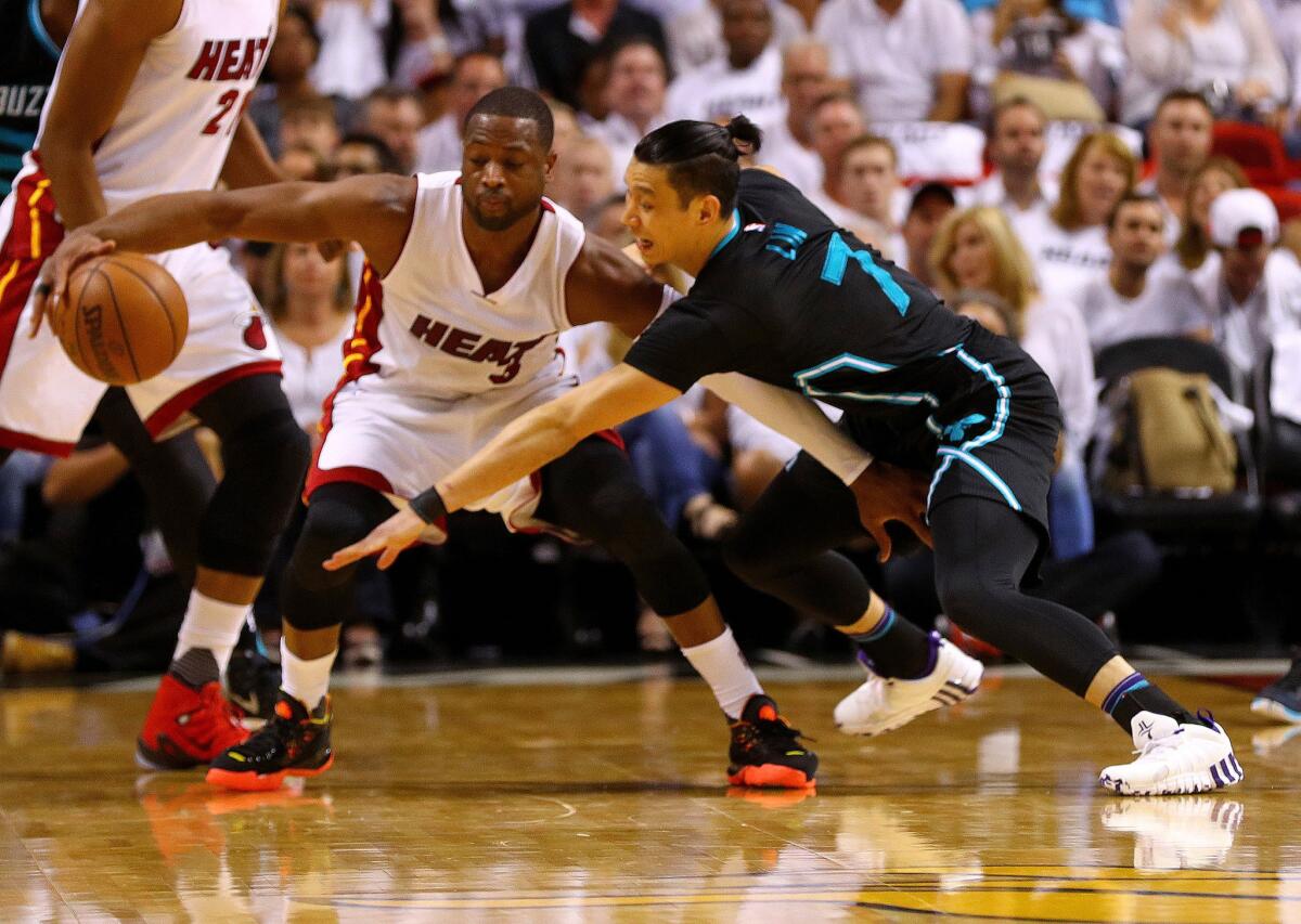 Heat guard Dwyane Wade keeps the ball out of the reach of Hornets guard Jeremy Lin during a playoff game on May 1.