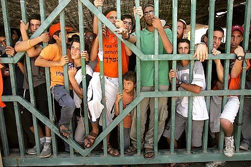 Residents and supporters in the settlement of Neve Dekalim stand at the main entrance to prevent police from delivering evacuation notices.