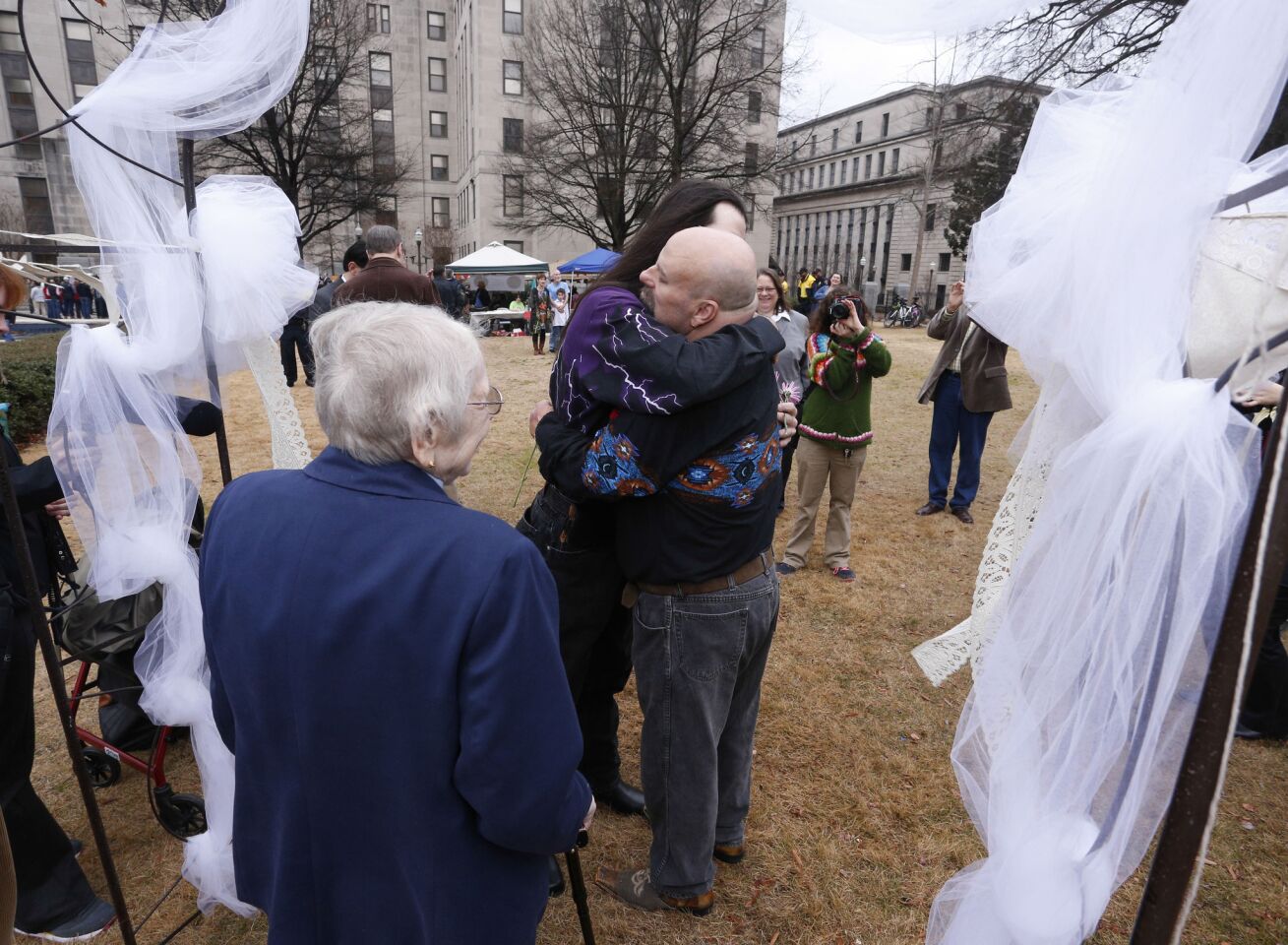 Steve Davis, left, and James Farless hug after being married by the Rev. Marge Ragona in Birmingham's Linn Park.