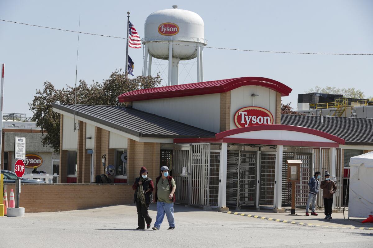 People walk outside a Tyson Foods plant.