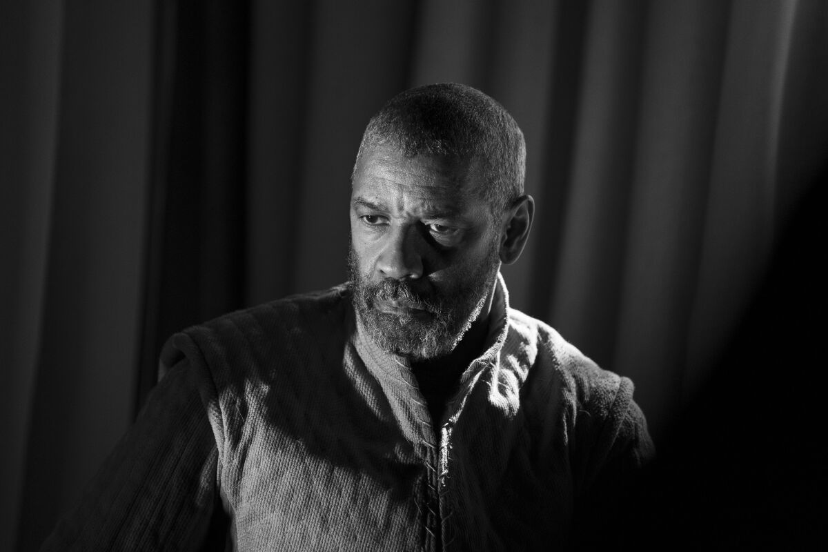 In a black and white film still, Denzel Washington is seen looking serious while in costume