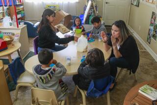 Teacher Elizabeth Garza (left) and YMCA Childcare Resource Service quality support specialist Marlene Fuentes (right) work with children during snack time on May 1, 2019 in Vista, California.