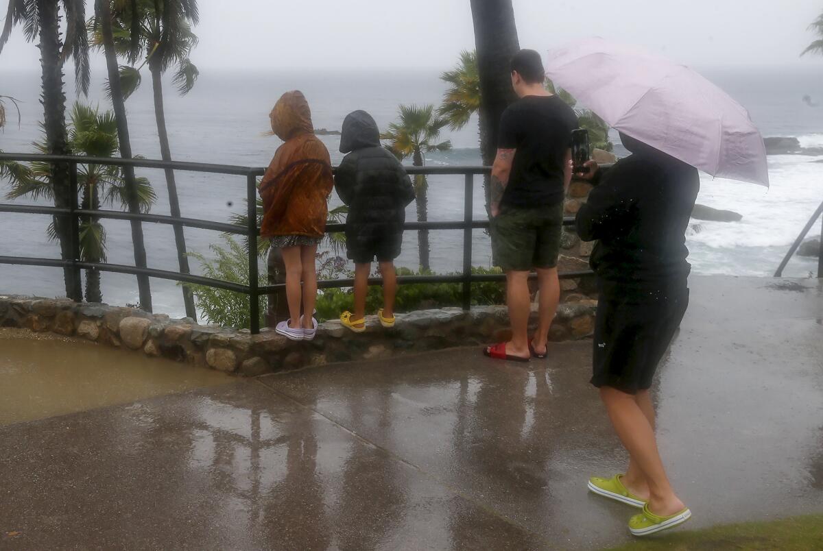 The Reyes family from Lake Arrowhead look over the rail at Heisler Park in Laguna Beach Sunday afternoon.