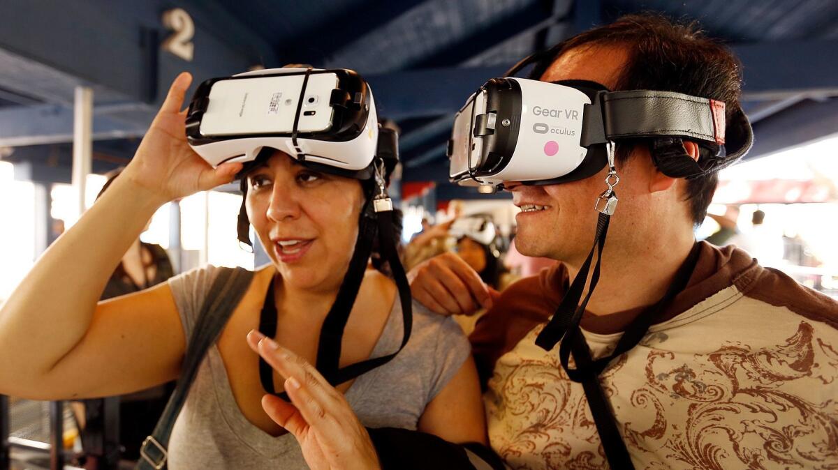 Jenny Alvarez, left, and Alfonso De Elias prepare to ride the New Revolution Virtual Reality roller coaster at Six Flags Magic Mountain in Valencia last year.