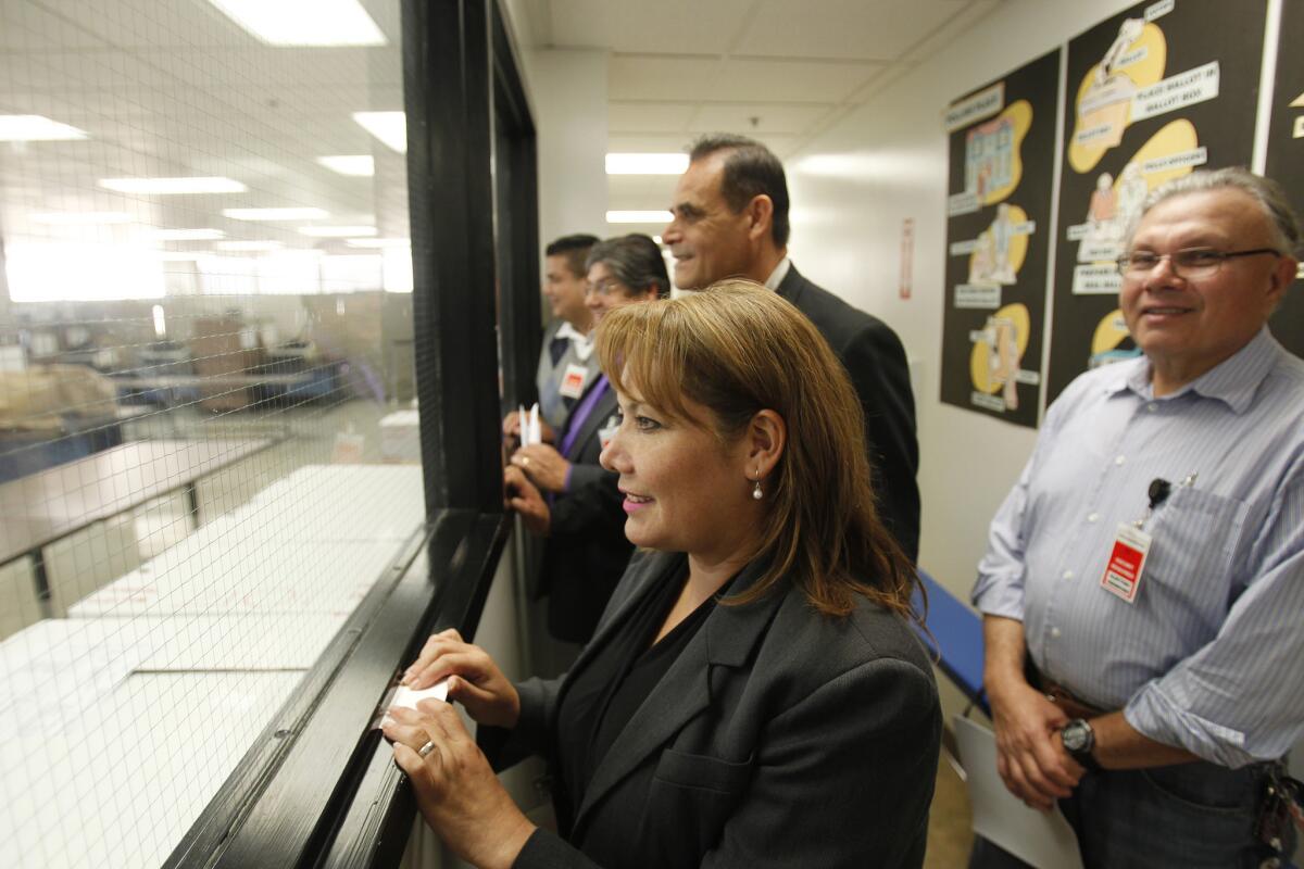 Patty Lopez, left, watches as ballots are counted in her 2014 race against then-incumbent Raul Bocanegra, who she bested by less than 500 votes. (Allen J. Schaben / Los Angeles Times)
