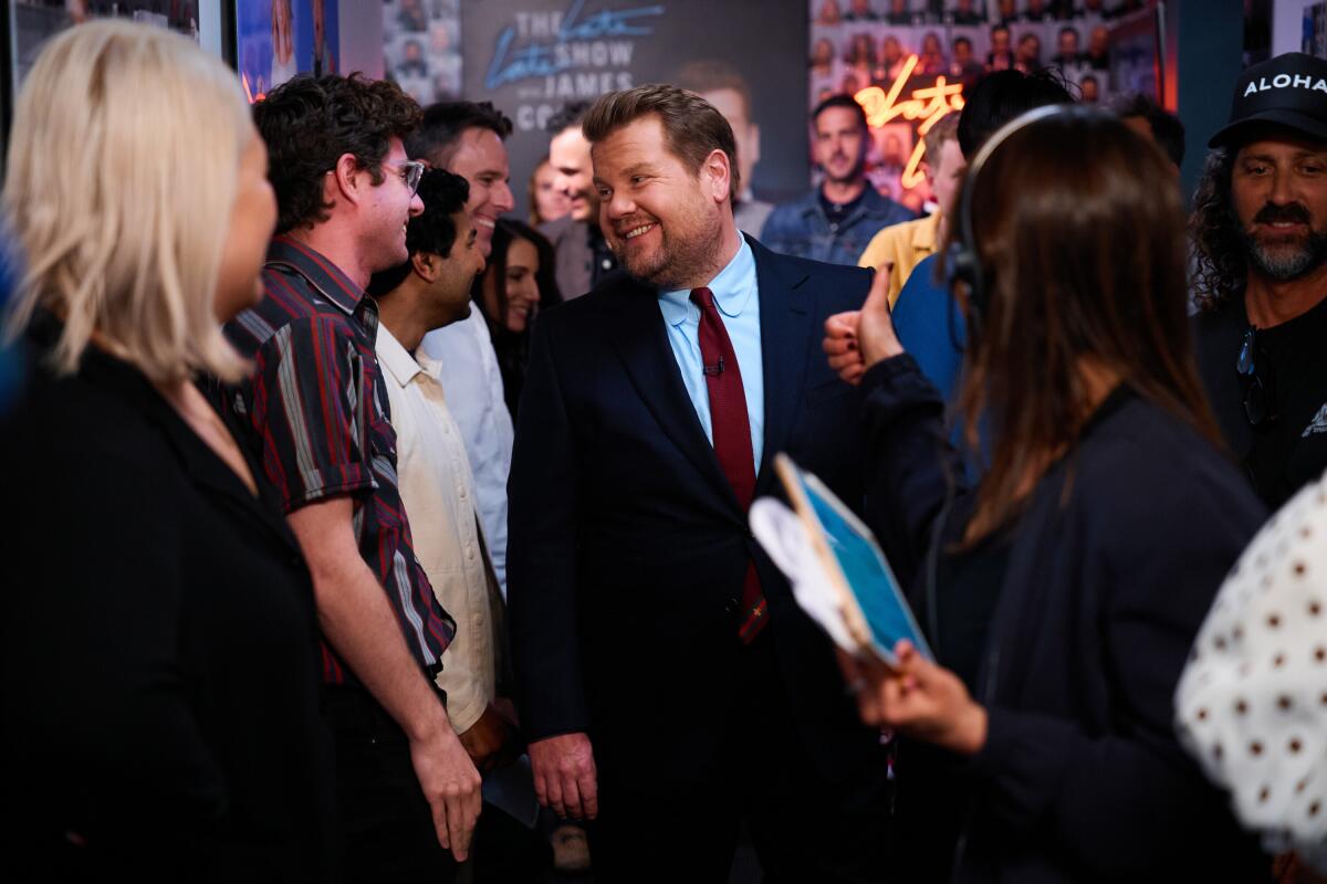 James Corden walking through a crowd of people.