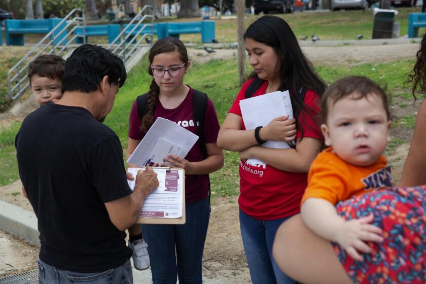 Liz Moughon  Los Angeles Times YOUTH volunteers America Barrera and Jimena Flores speak to residents in L.A.’s MacArthur Park about the importance of participation in the census.