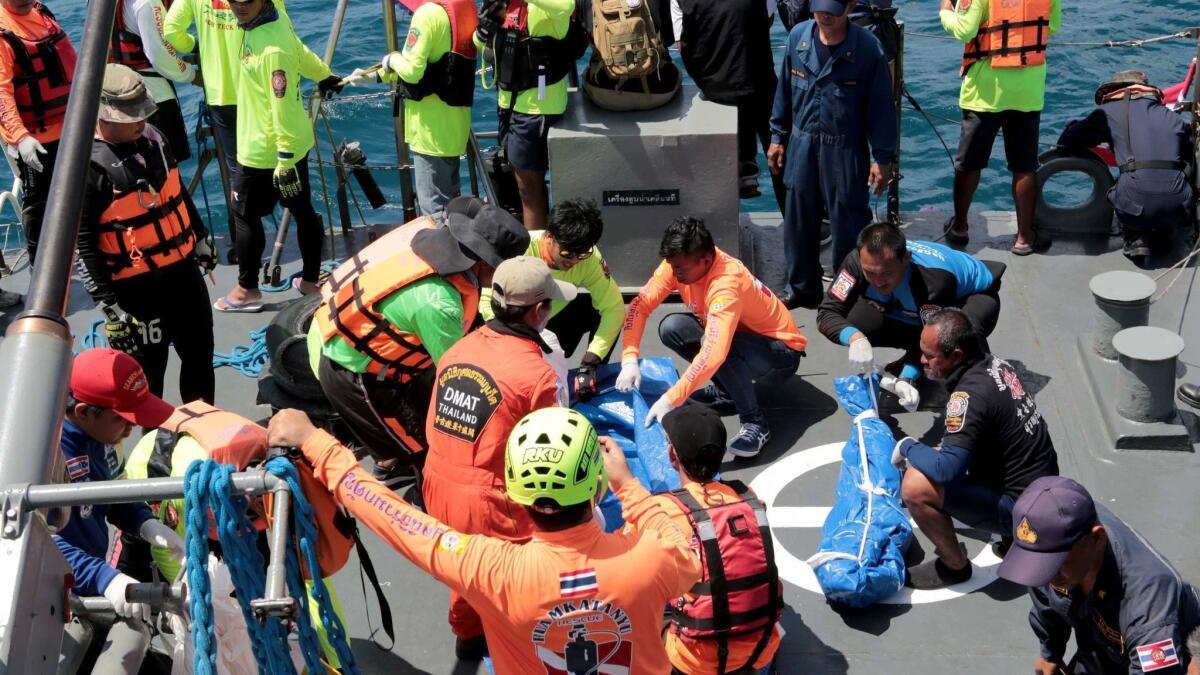 Thai rescue workers tends to bodies aboard a navy vessel after the sinking off Phuket.