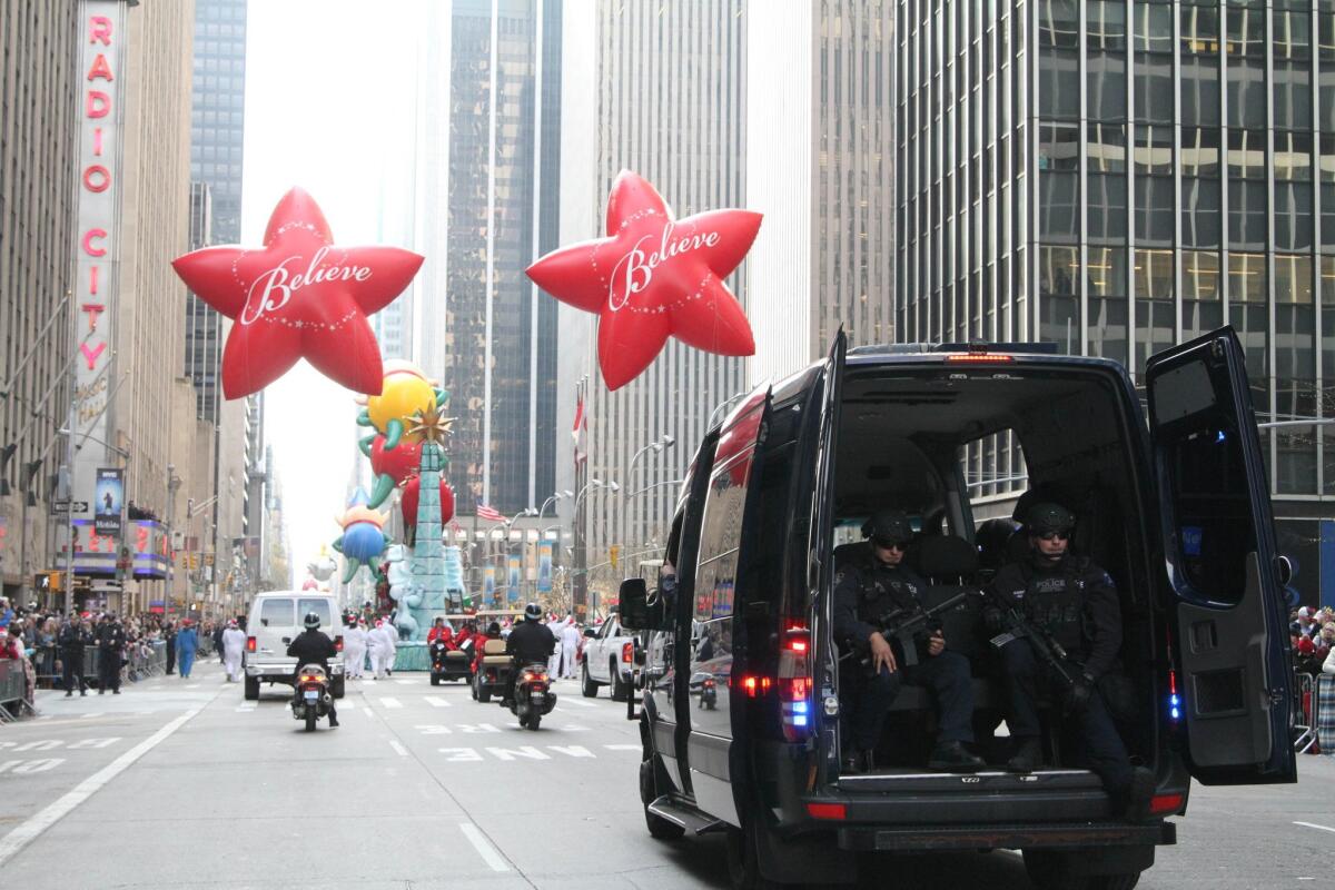 A police vehicle makes its way down New York's Sixth Avenue behind the Macy's Thanksgiving Day Parade on Thursday.