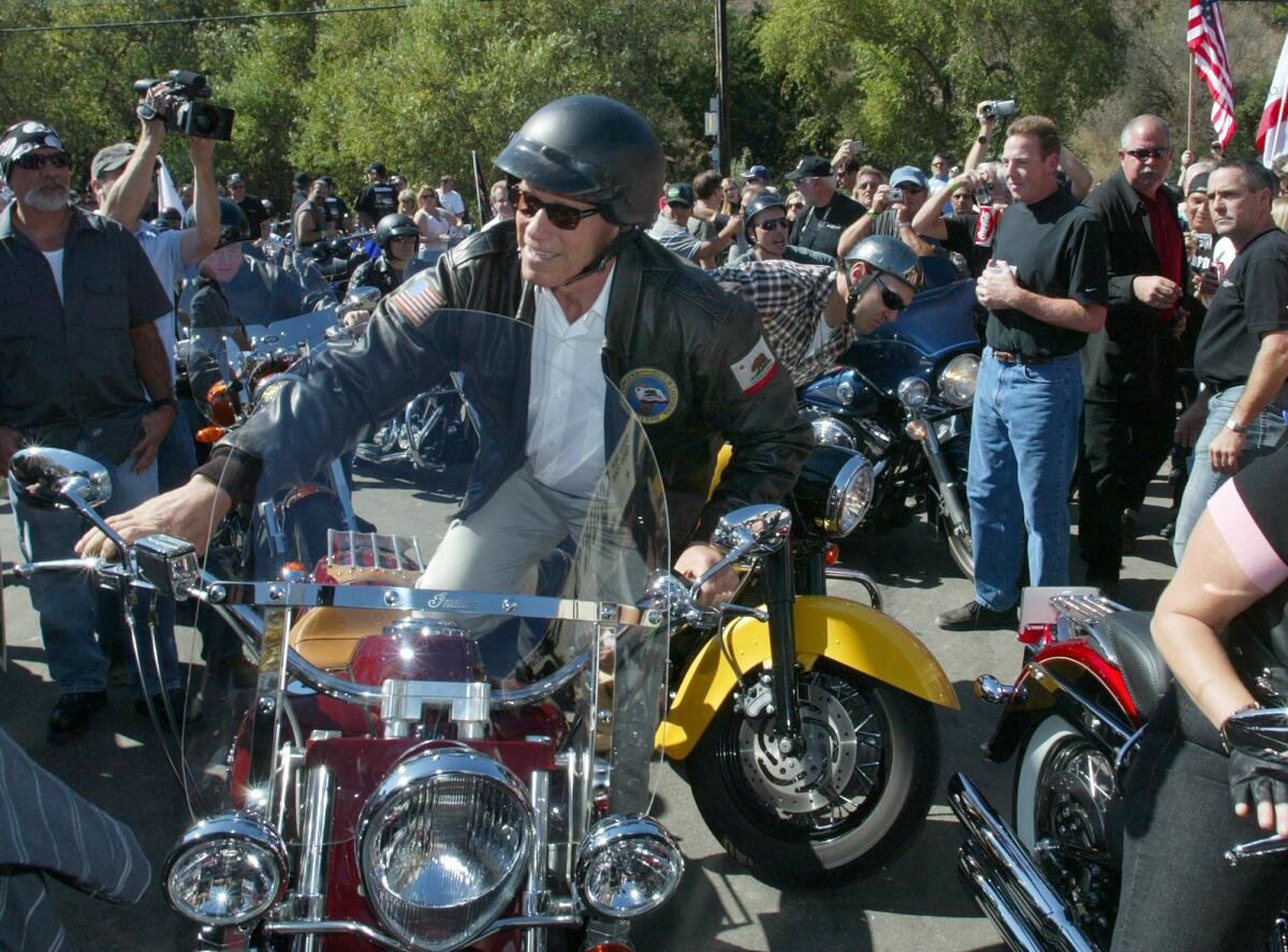 Then-Gov. Arnold Schwarzenegger rides a motorcycle into a campaign stop at Cook's Corner in Trabuco Canyon in 2006.
