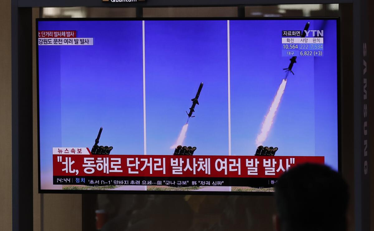 People at Seoul's railway station watch a TV airing reports of North Korean missiles. The reports use file images of missiles. 