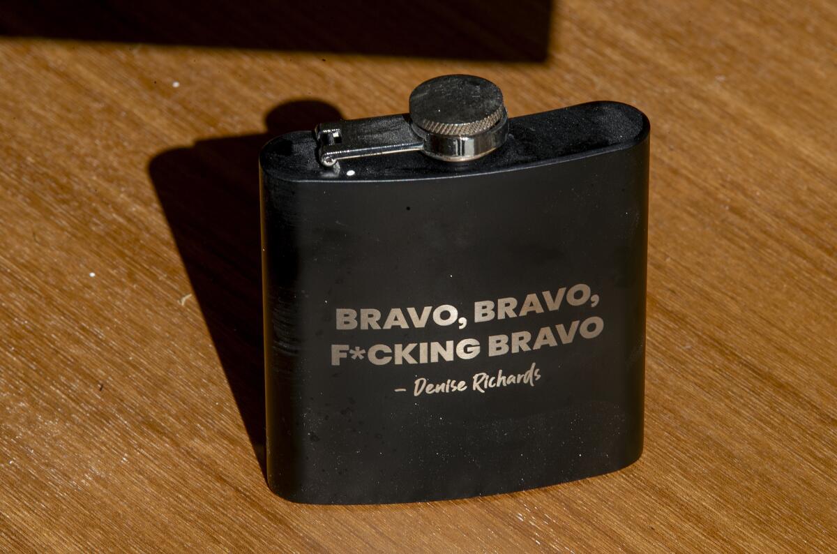 一个黑色烧瓶，上面写着“Bravo”、“Bravo”、“F*cking Bravo”、“Denise Richards”等金色字母。