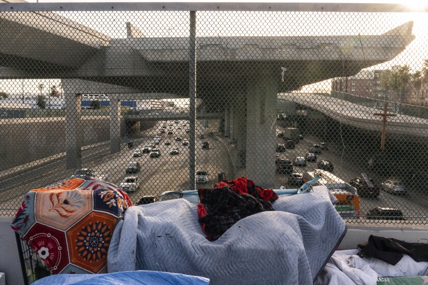 FILE - A homeless encampment is seen on a bridge over the CA-110 freeway, Wednesday, Dec. 15, 2021, in Los Angeles. The Los Angeles City Council has voted to ban homeless encampments within 500 feet of schools and daycare centers. The council voted Tuesday, Aug. 2, 2022, to broaden an existing ban on sleeping or camping near the facilities. (AP Photo/Damian Dovarganes,File)